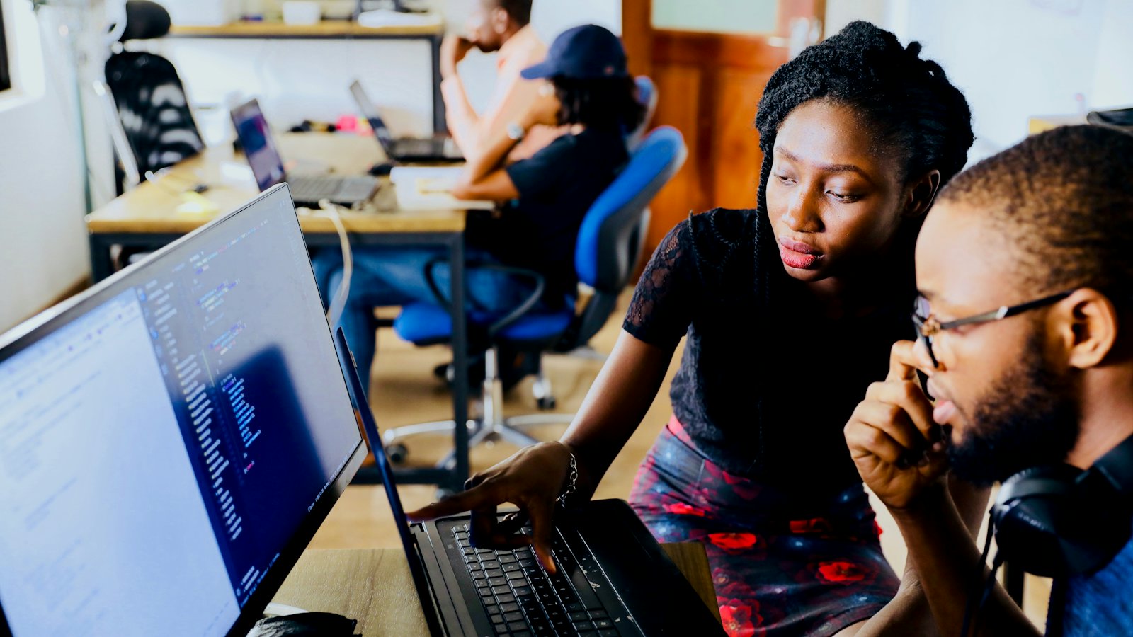Two people looking at a monitor together, discussing what is on screen