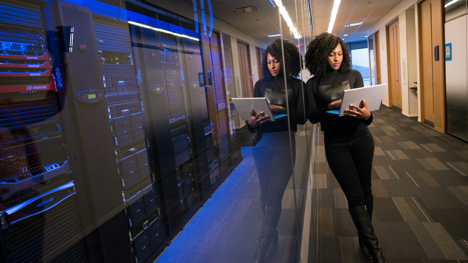 A data center corridor lit in blue, server racks on both sides