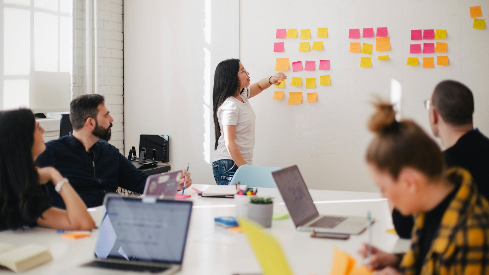 A team planning at a whiteboard covered in sticky notes